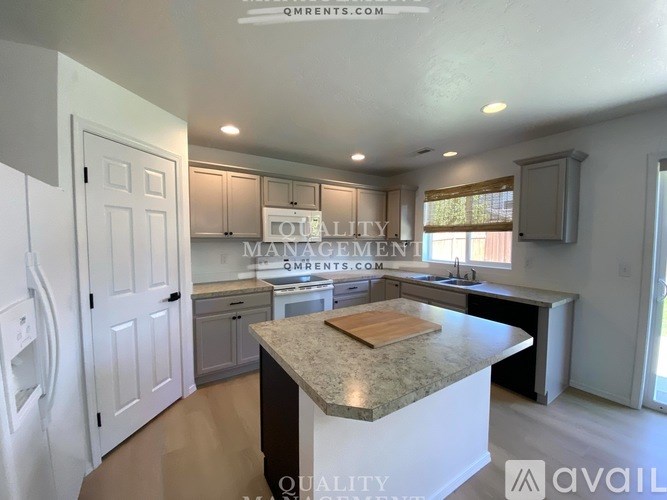 A kitchen with a marble countertop and white cabinets.
