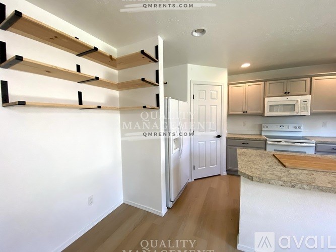 A kitchen with a white door and cabinets.