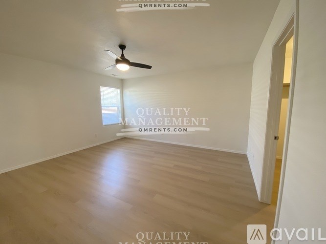 A room with a ceiling fan and wooden flooring is available for rent.