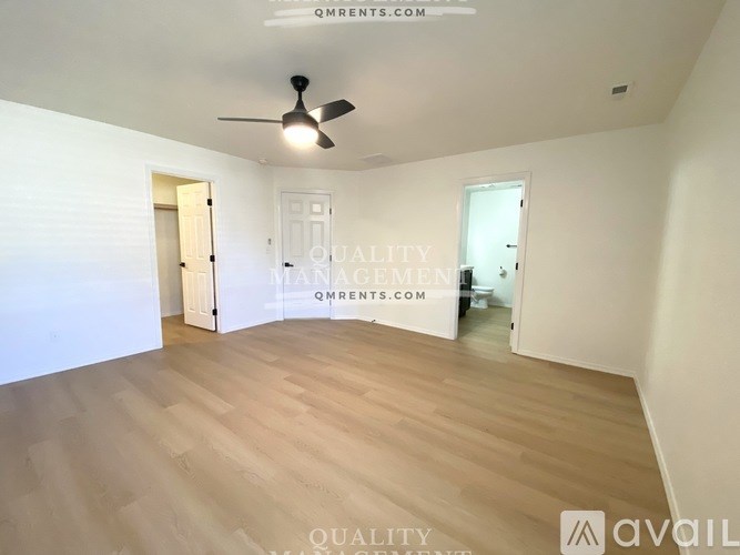 A room with wooden flooring and a ceiling fan.
