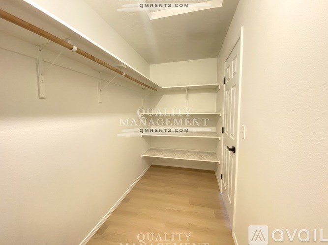 A white hallway with a door on the right and a wall on the left.