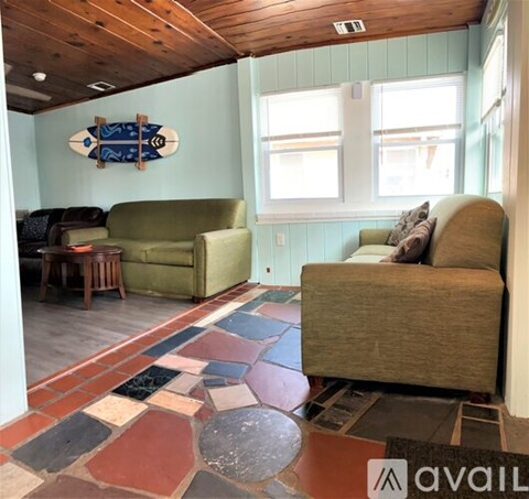 A living room with a green couch and a wooden ceiling.
