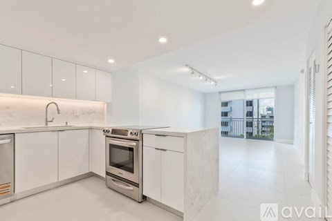 A modern kitchen with white cabinets and appliances.