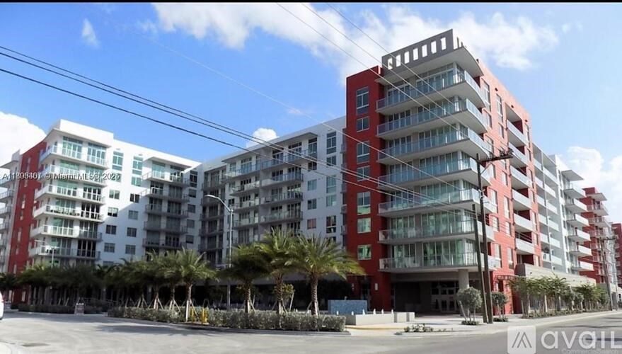 A large red and white building with palm trees in front.