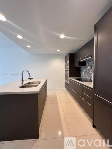 A modern kitchen with dark brown cabinets and a white countertop.