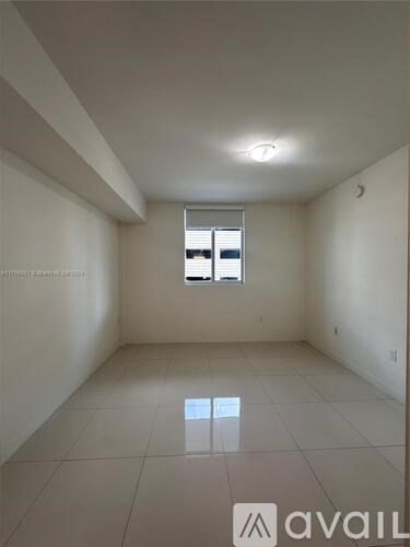 A spacious room with a window and a tiled floor.