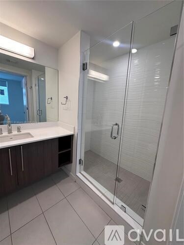A bathroom with a walk-in shower and a sink.