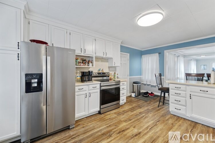 A kitchen with a refrigerator, oven, and cabinets.
