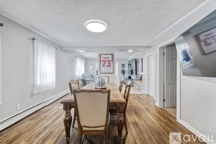 A dining room with wooden floors and a white ceiling.