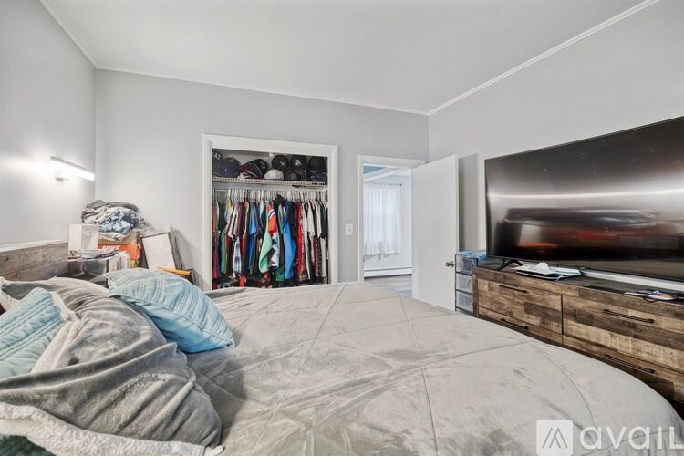 A bedroom with a bed, a wardrobe, and a TV.