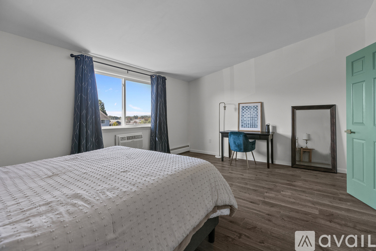 A bedroom with a large bed and a desk with a chair.