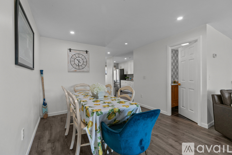 A dining room with a table set for two and a blue chair.