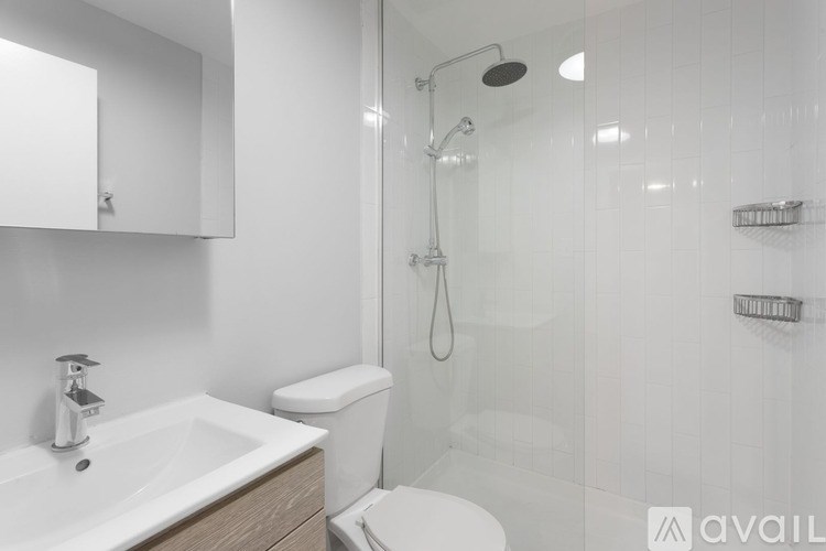 A white sink with a mirror above it and a toilet behind it.