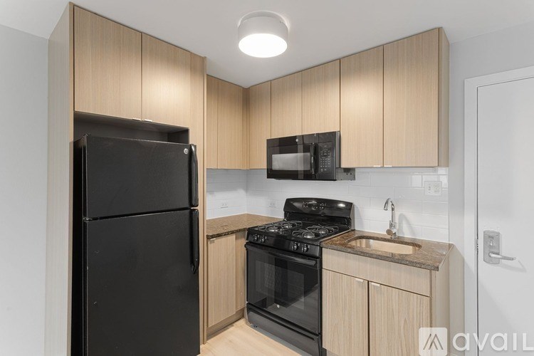 A kitchen with black appliances and wooden cabinets.
