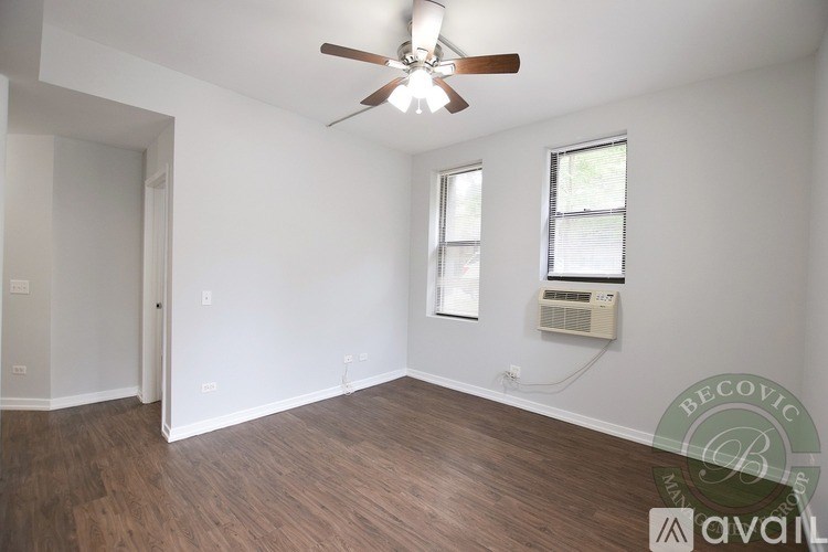 A room with a ceiling fan and wooden flooring.