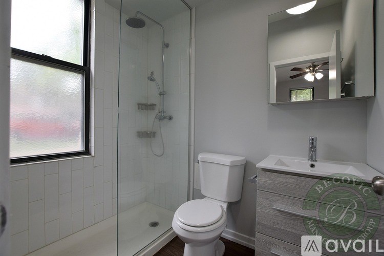 A white toilet in a bathroom with a glass shower stall.