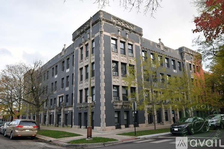 A grey building with a tree in front of it.