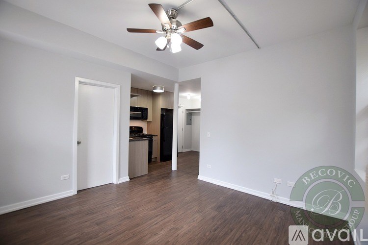 A room with a ceiling fan and wooden flooring.