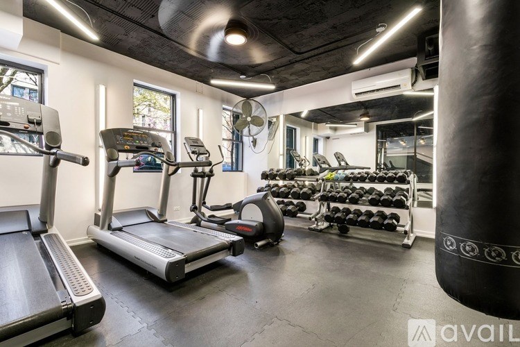 A gym with treadmills, elliptical machines, and a punching bag.
