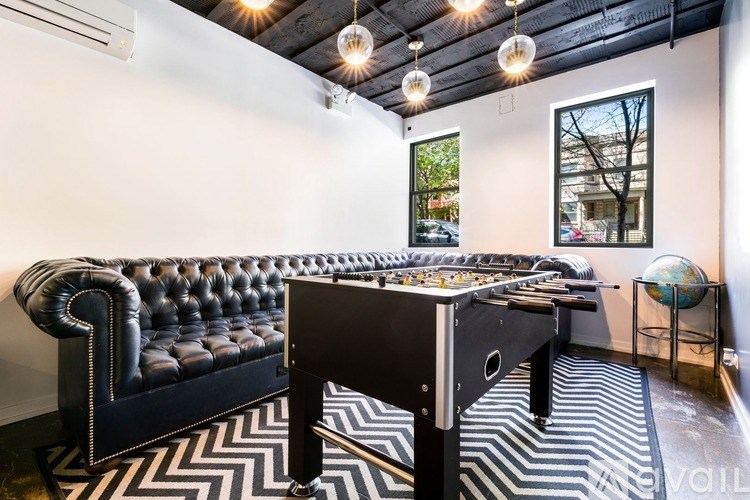 A black and white striped rug covers the floor of a room with a pool table and a black leather couch.