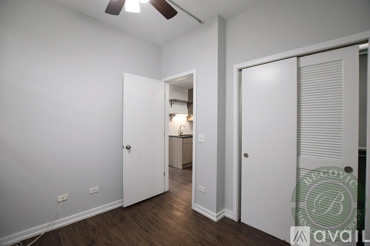 A room with a white door and a brown floor.