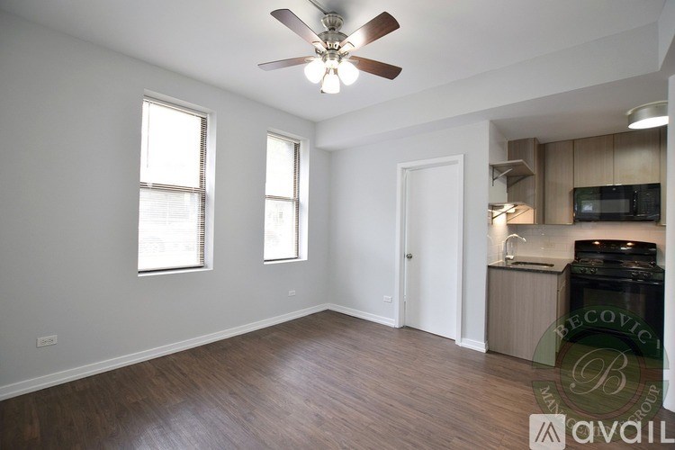 A room with a ceiling fan and wooden flooring.