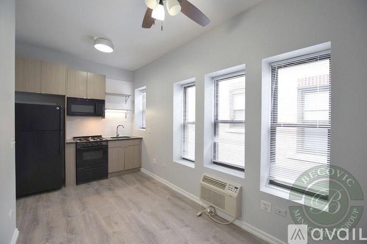 A well-lit kitchen with a black refrigerator, microwave, and stove.