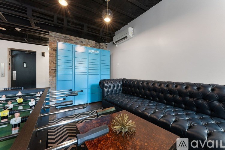 A foosball table is in a room with a black couch.