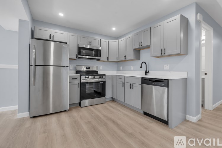 A modern kitchen with stainless steel appliances and wooden floors.