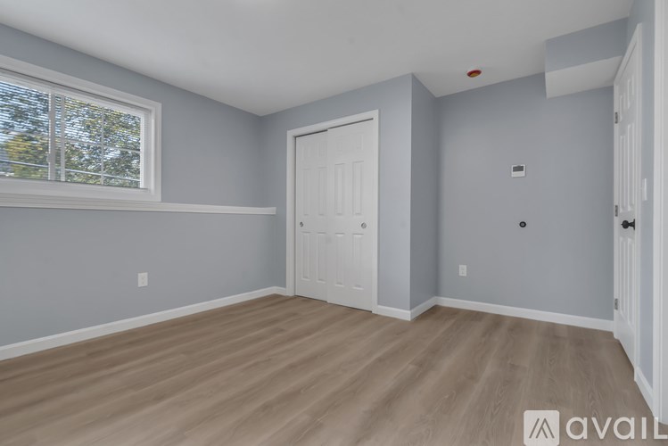 A room with light grey walls and a white door.