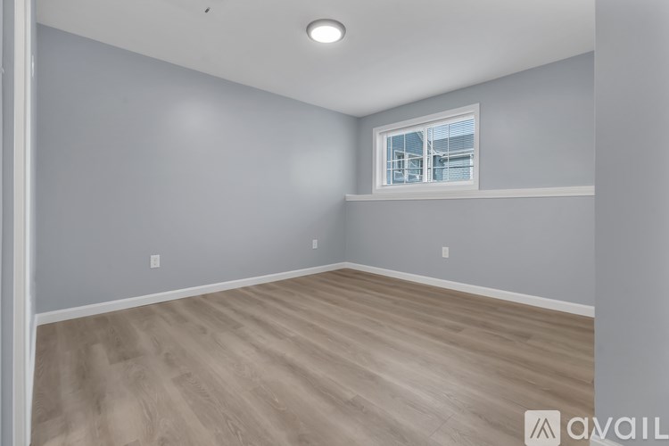 A room with a window and wooden flooring.