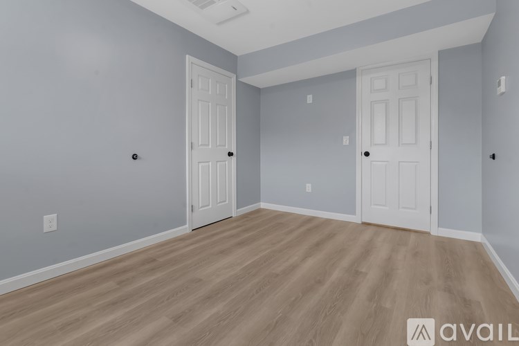 A room with two doors and a wooden floor.