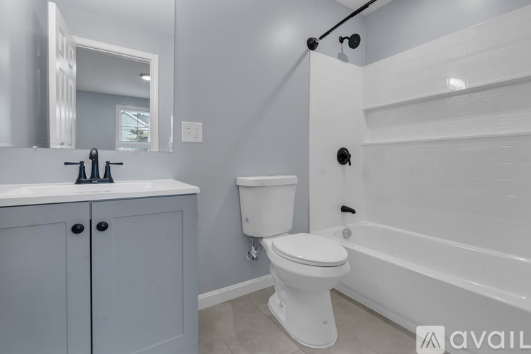 A bathroom with a white toilet and a white bathtub.