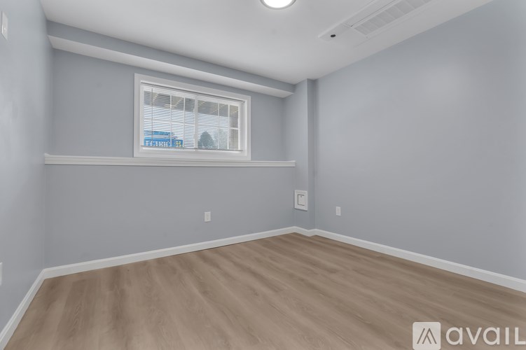 A room with a window and wooden flooring.