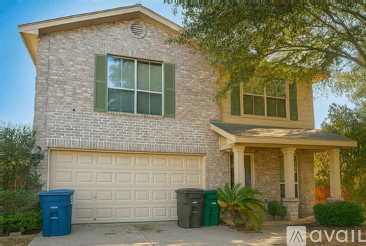A house with a garage and a tree in front.