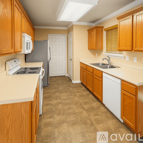 A kitchen with wooden cabinets and a white dishwasher.