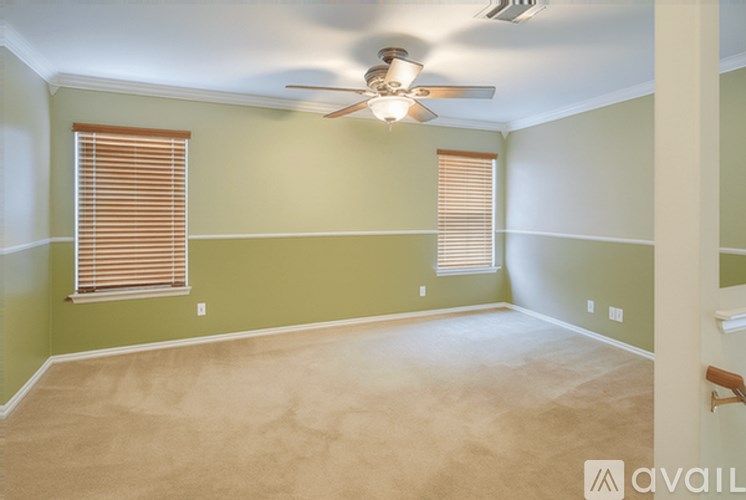 A room with a ceiling fan and carpeted floor.