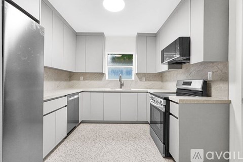 A kitchen with a refrigerator, oven, and cabinets.
