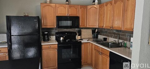 A kitchen with black appliances and wooden cabinets.