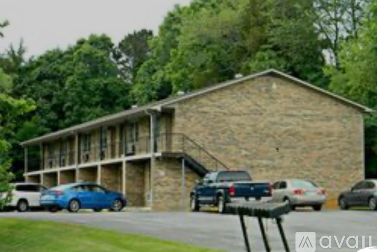 A parking lot with cars and a building in the background.
