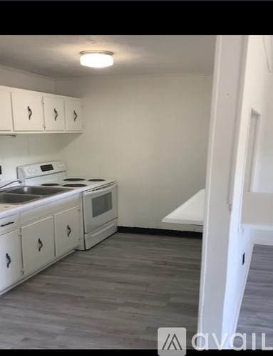 A kitchen with white cabinets and a white oven.
