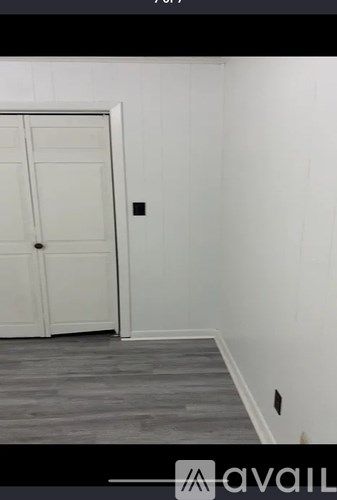 A white door is in a room with wooden flooring.