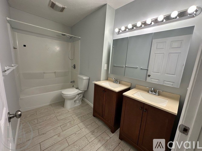 A bathroom with a toilet, sink, and mirror.