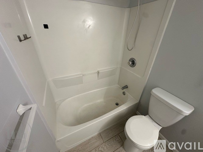 A white bathroom with a toilet, tub, and shower.