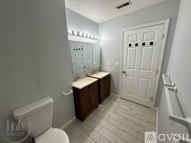 A bathroom with a toilet, sink, and mirror.