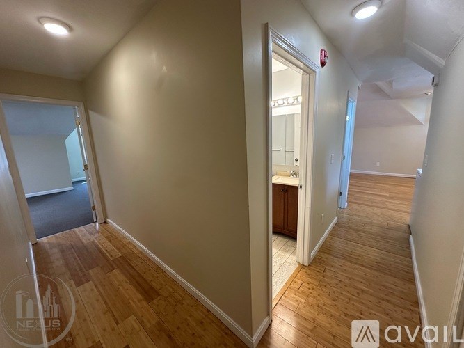 A hallway with wooden floors and white walls.