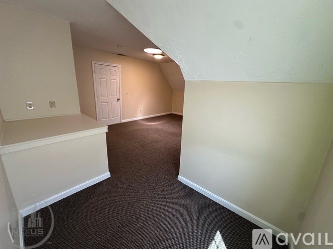 A room with a carpeted floor and a white door.