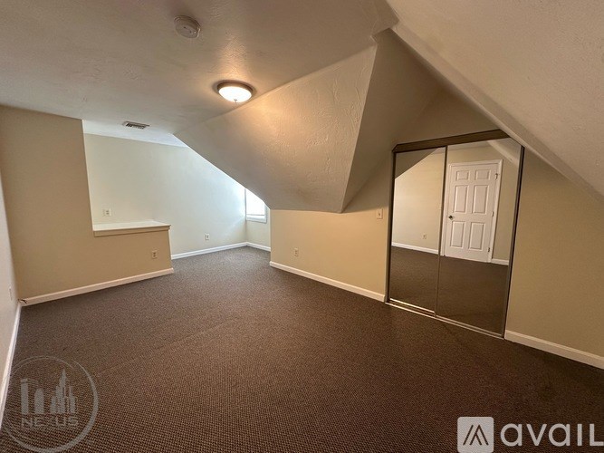 A room with a carpeted floor and a door leading to another room.