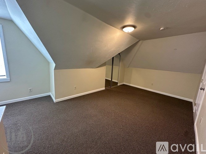 A carpeted room with a door and a window.