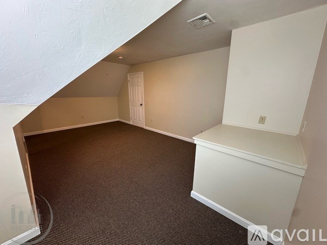 A room with a carpeted floor and a white door.